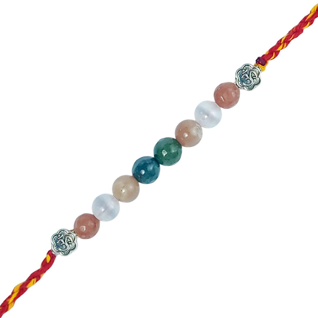 Multicolored beaded rakhi with silver charms on a white background