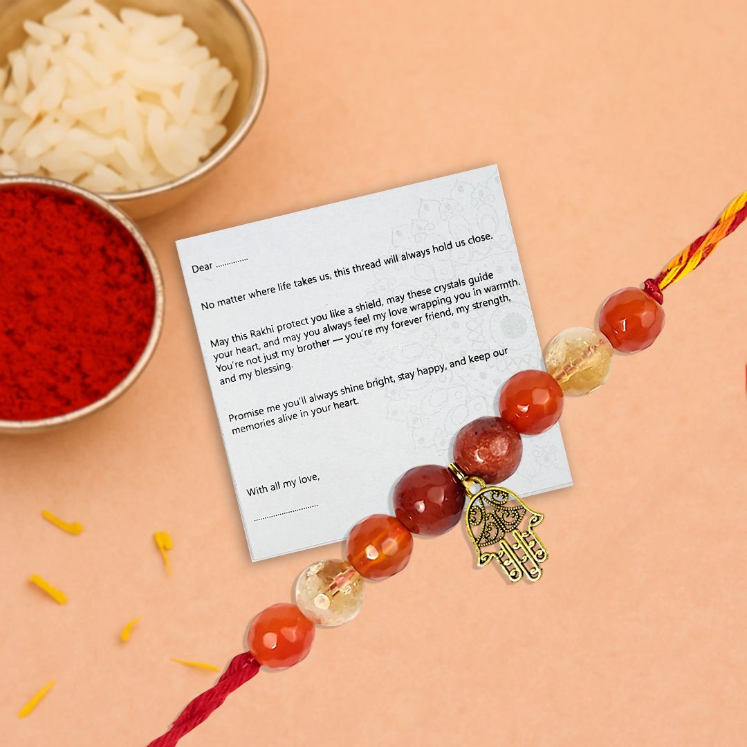 rakhi with red orange and transparent white crystal beads with a golden hand charm in between