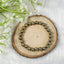 Gold beaded bracelet on a wooden slice with white flowers in the background