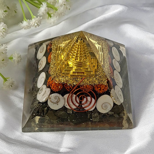Decorative crystal with gold temple-like structure on a white fabric background