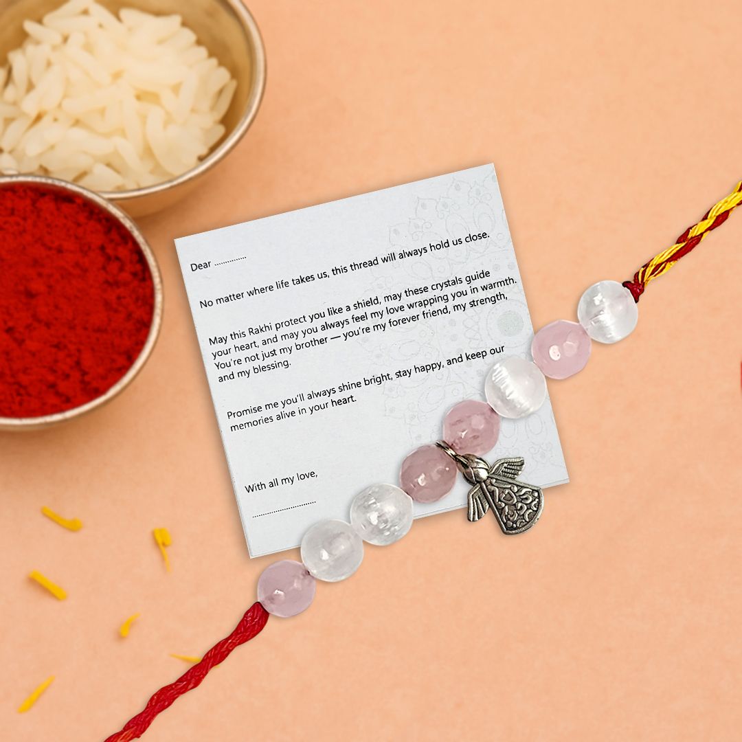 rakhi with butterfly charm on a card with text, next to bowls of red and white powder on a peach background
