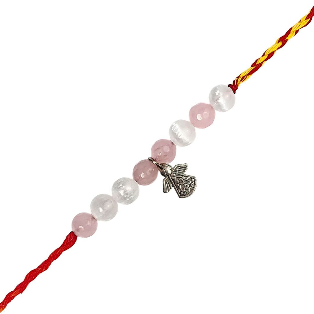 rakhi with pink and white beads and a silver charm on a white background