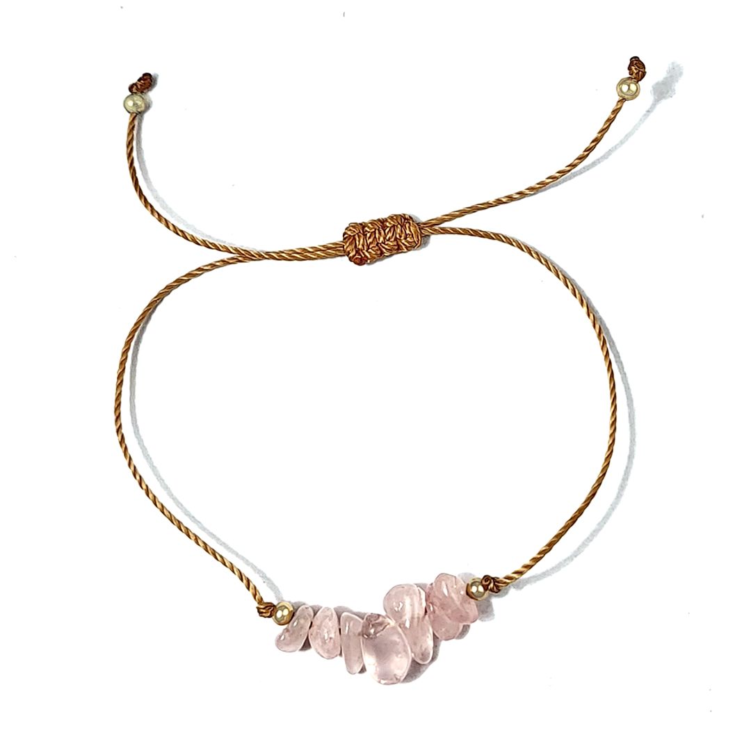 bracelet with pink stone beads and gold thread on a white background