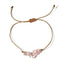 bracelet with pink stone beads and gold thread on a white background