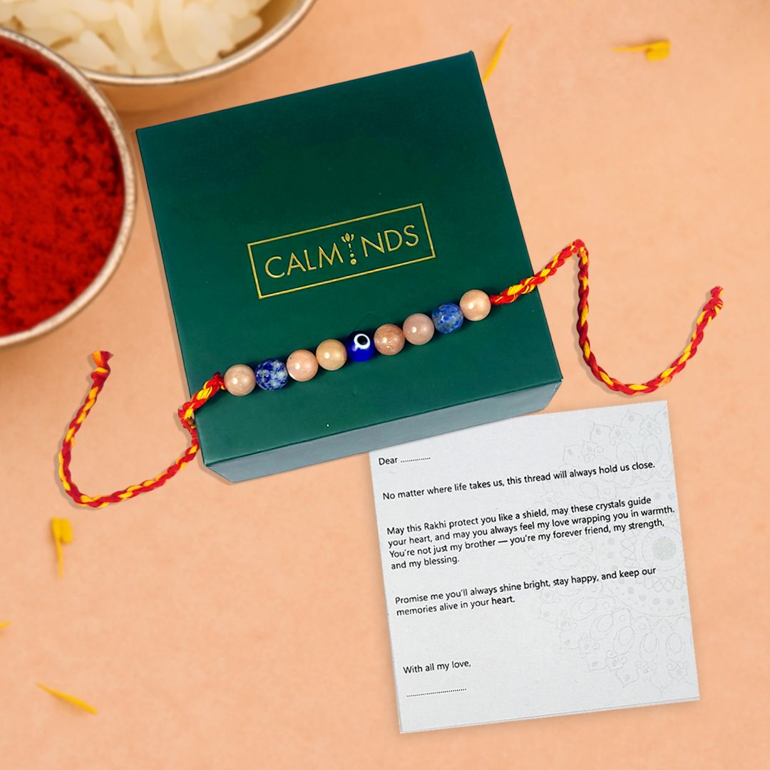Colorful beaded rakhi with a message card on a green box, set against a beige background.