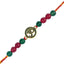 rakhi with green and red beads and a central gold pendant on a white background