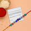 Colorful beaded Rakhi with a letter on a peach background