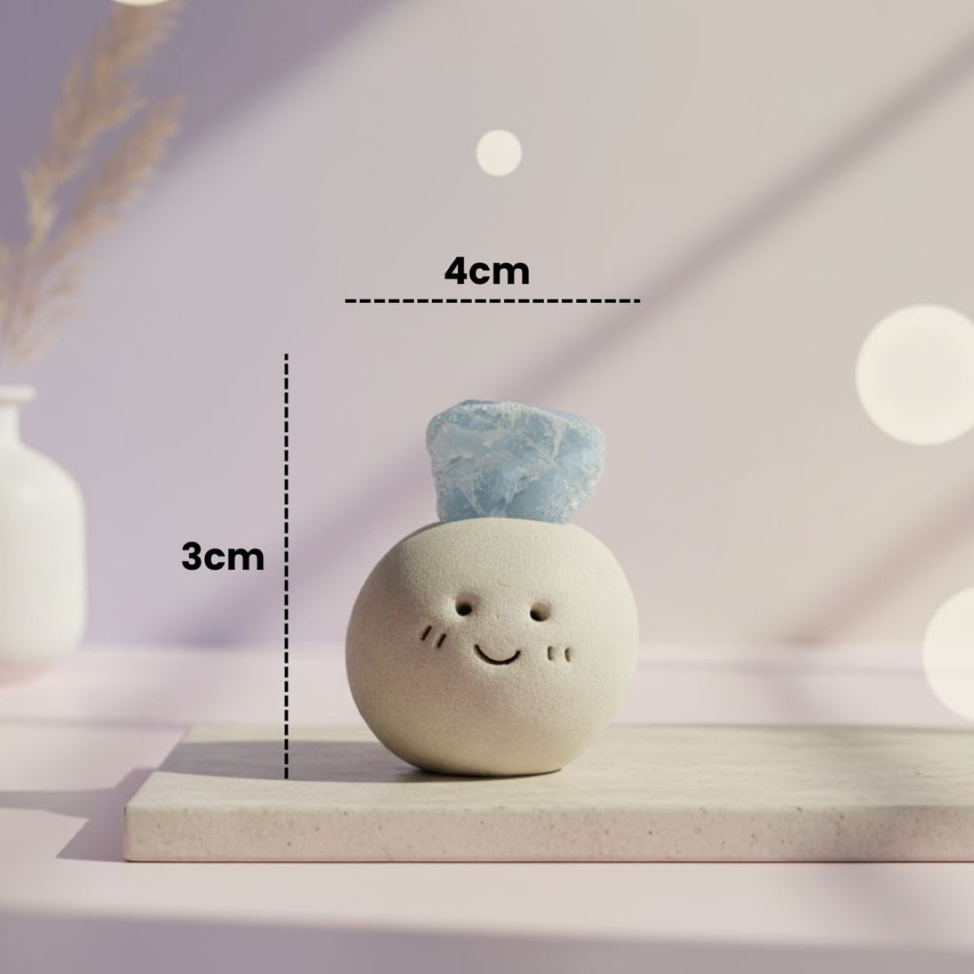 Small round ceramic figure with blue aquamarine crystal on top and figure measurements on a light background