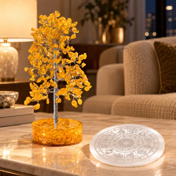 Citrine crystal tree beside a zodiac selenite charging plate on a living room table