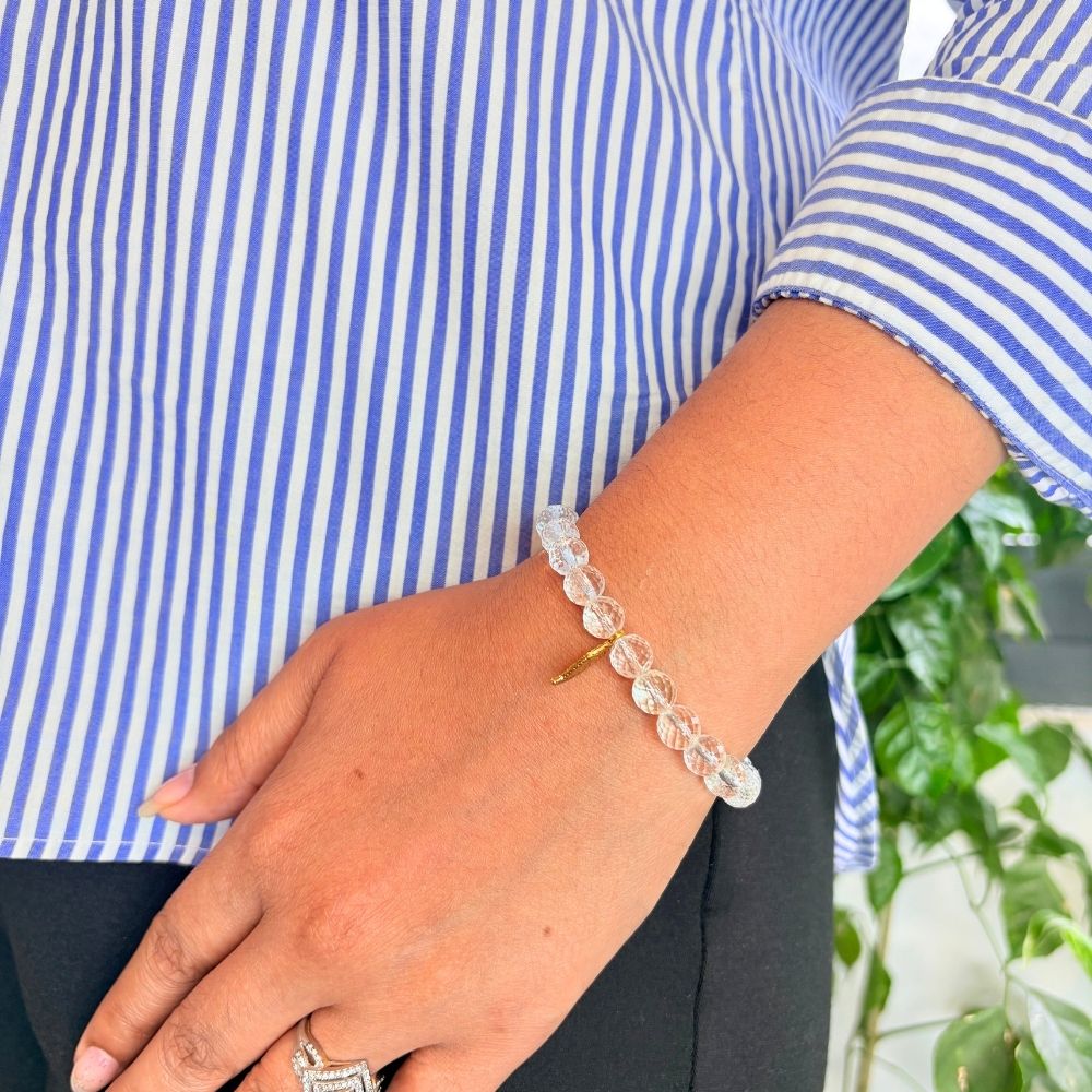 woman wearing a Clear Quartz Crystal Bracelet With Charm on her left hand