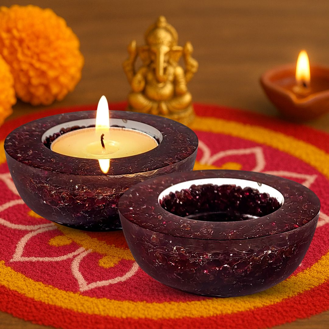 Decorative dark brown candle holders with lit candles on a colorful fabric background.
