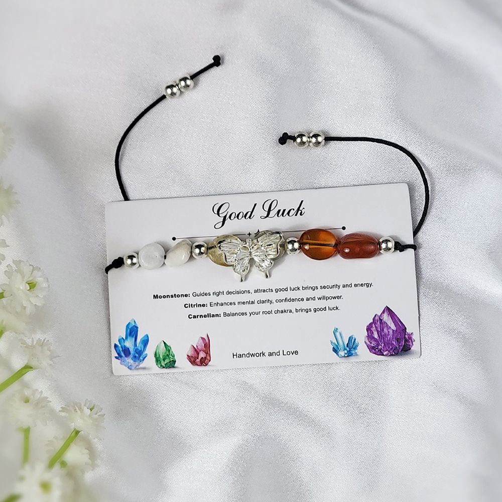 bracelet with stones on a card labeled good luck on a white fabric background