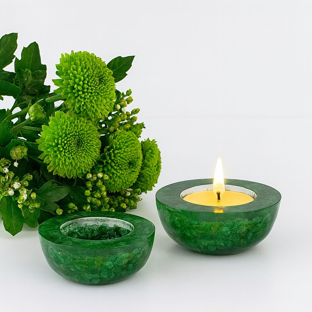 Two green candle holders with a lit candle and a bouquet of green flowers on a white background