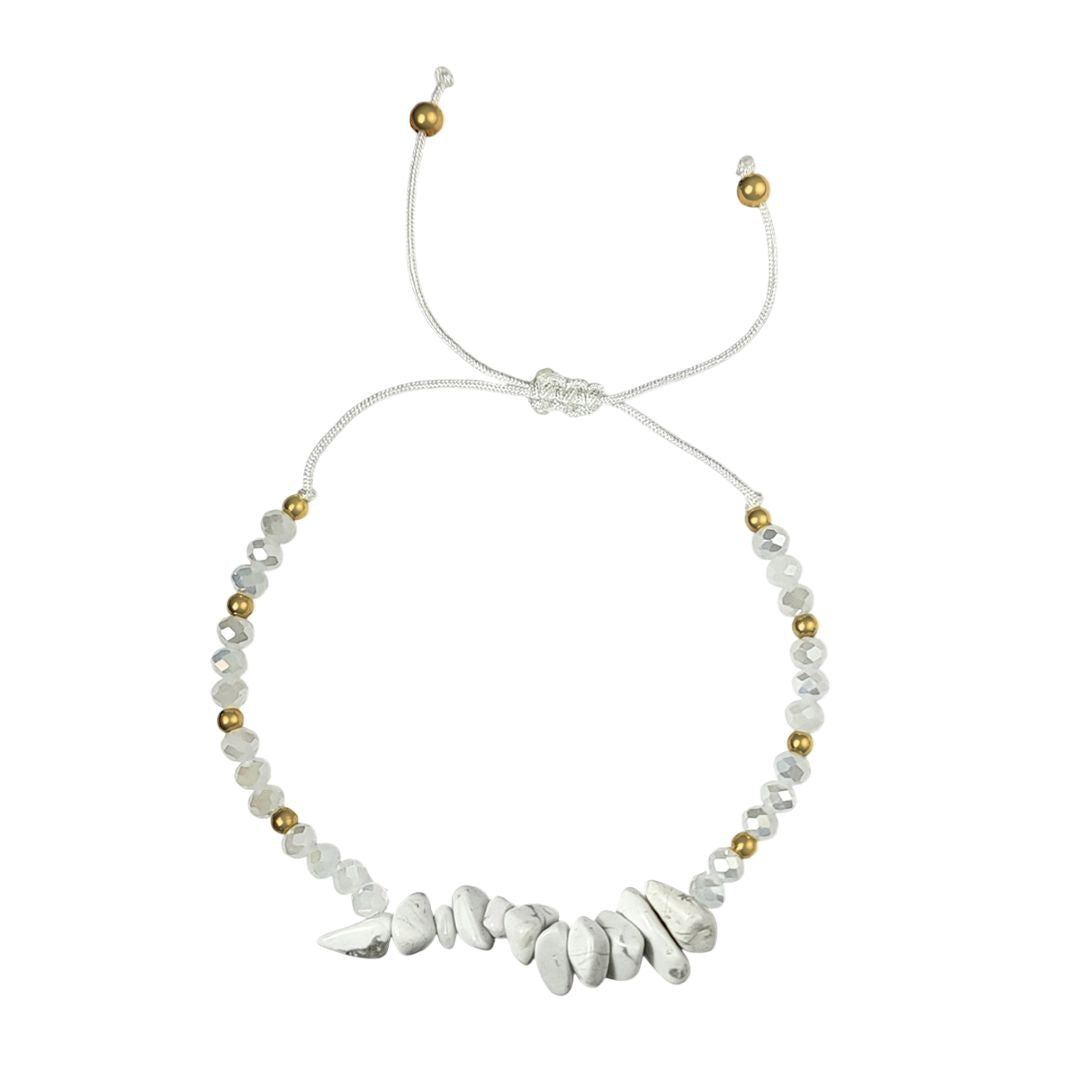 thread bracelet with white howlite stones and gold beads on a white background