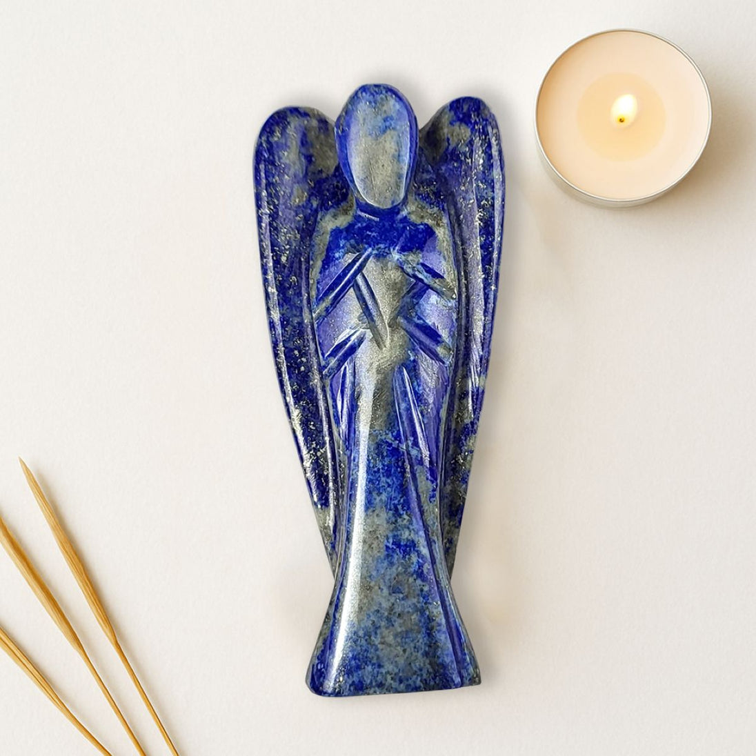 blue color lapis lazuli angel figurine on a white surface