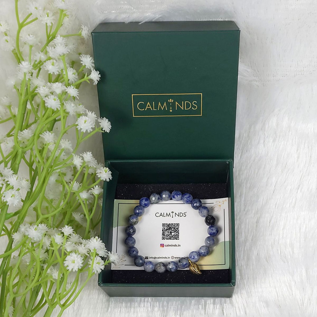 Blue beaded bracelet in a 'CALMINDS' box with flowers on the side