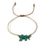 thread bracelet with green stone beads on a white background
