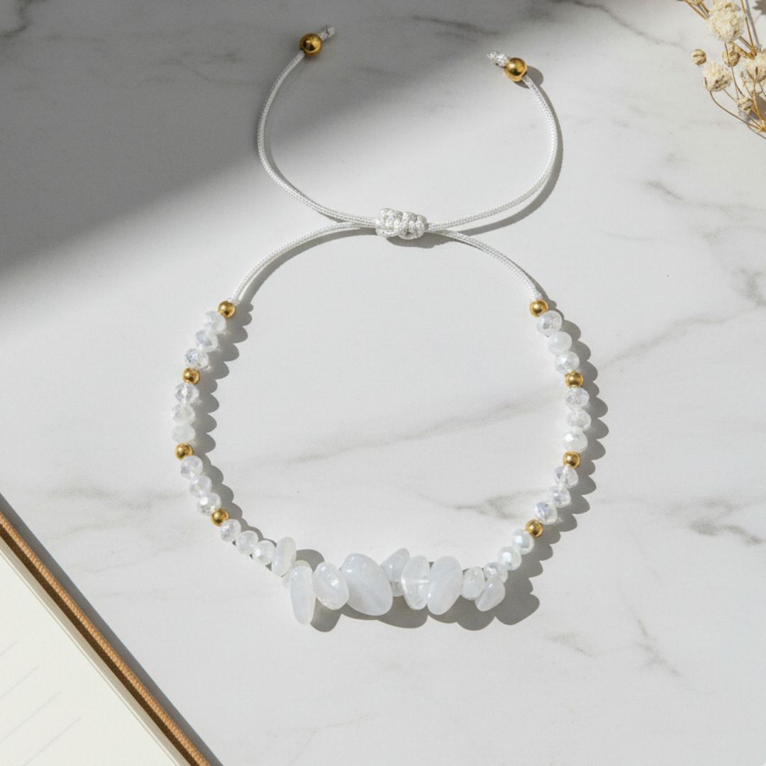 moonstone beaded thread bracelet with white stones and gold accents on a marble surface