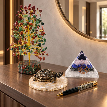 Multicolour crystal tree, pyrite turtle, orgonite pyramid and pyrite pen on a wooden console