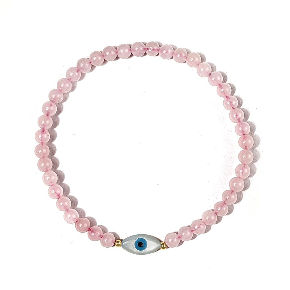 Pink beaded bracelet with a blue evil eye charm on a white background