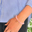 woman wearing a Rose Quartz Charm bracelet on her left hand