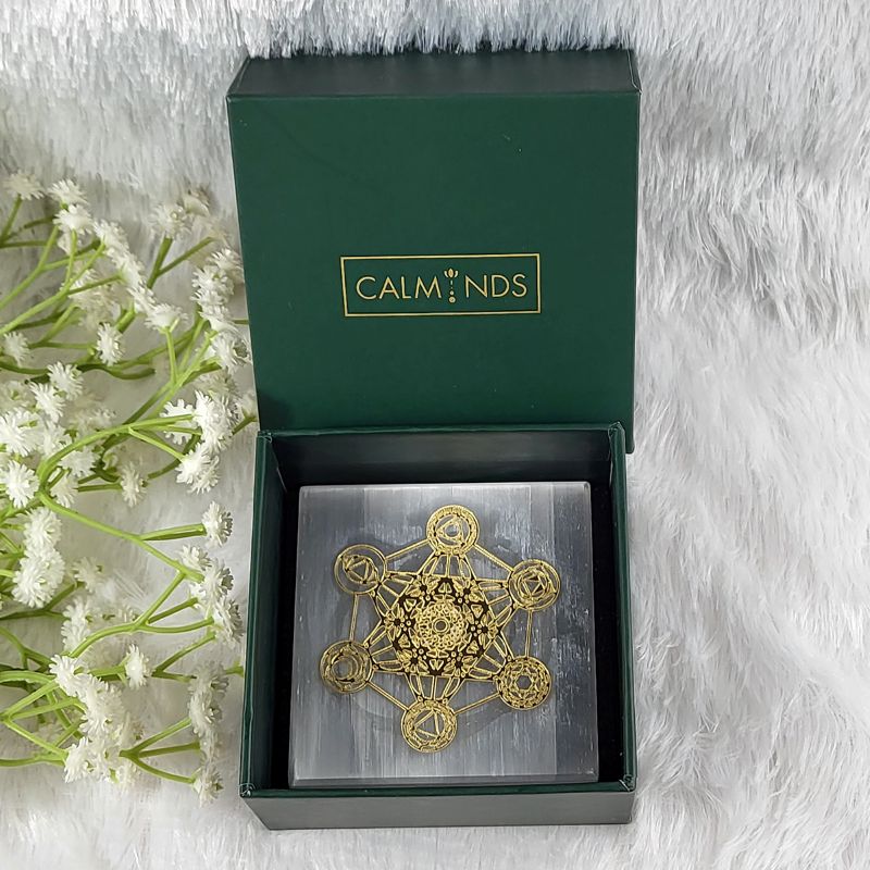 Decorative metal piece in a calminds box with white flowers on a light gray background