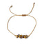 golden thread bracelet with  tiger eye stone beads on a white background