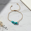 thread bracelet with turquoise stones on a marble surface