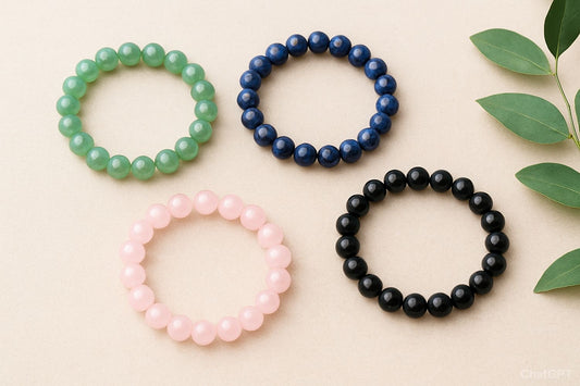 blue, green, pink and black bracelet on pink background next to leaf