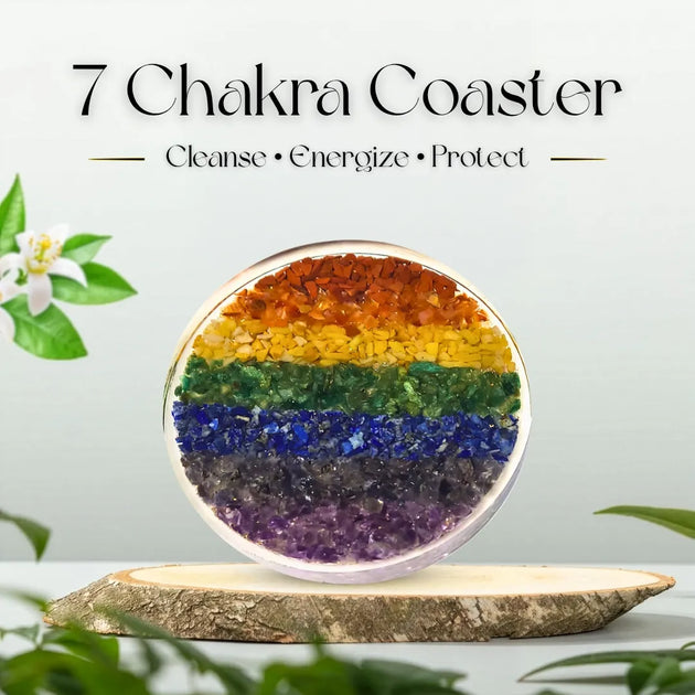 7 Chakra Coaster with colorful layers on a wooden stand, surrounded by greenery.