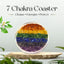 7 Chakra Coaster with colorful layers on a wooden stand, surrounded by greenery.