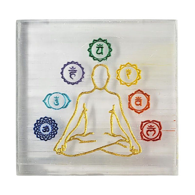 Transparent patch with a gold outline of a meditating figure and seven chakra symbols above it on a white background.