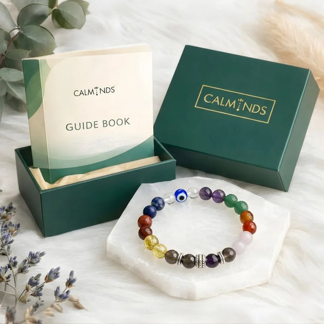 Colorful beaded bracelet on a white stand with 'Calminds' branded box and guidebook in the background.
