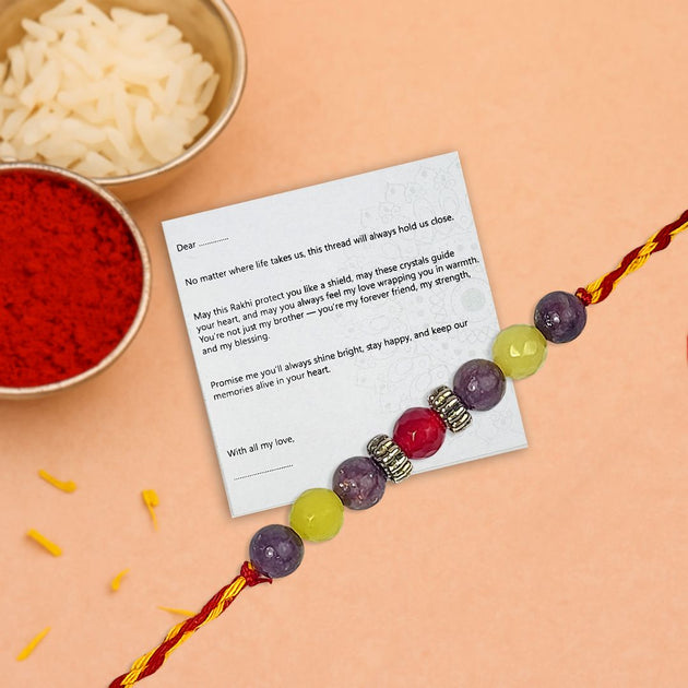 Rakhi with a card on a peach background