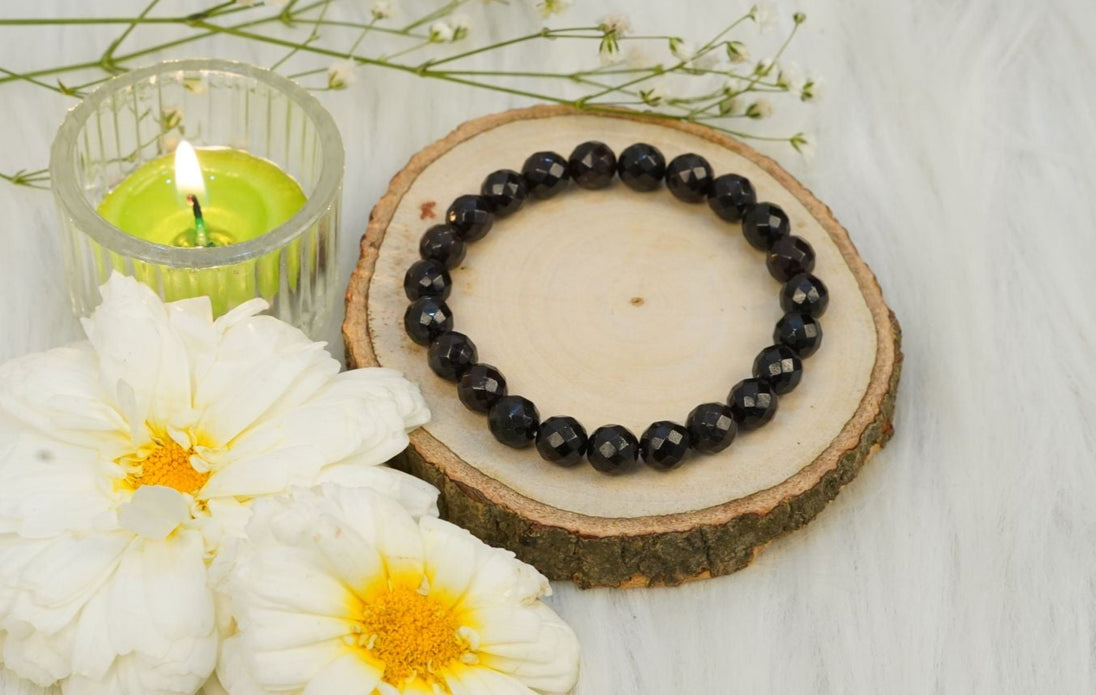 black onyx crystal bracelet next to candle and flowers