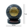 Black crystal ball with gold geometric design and measurement scale on a white background