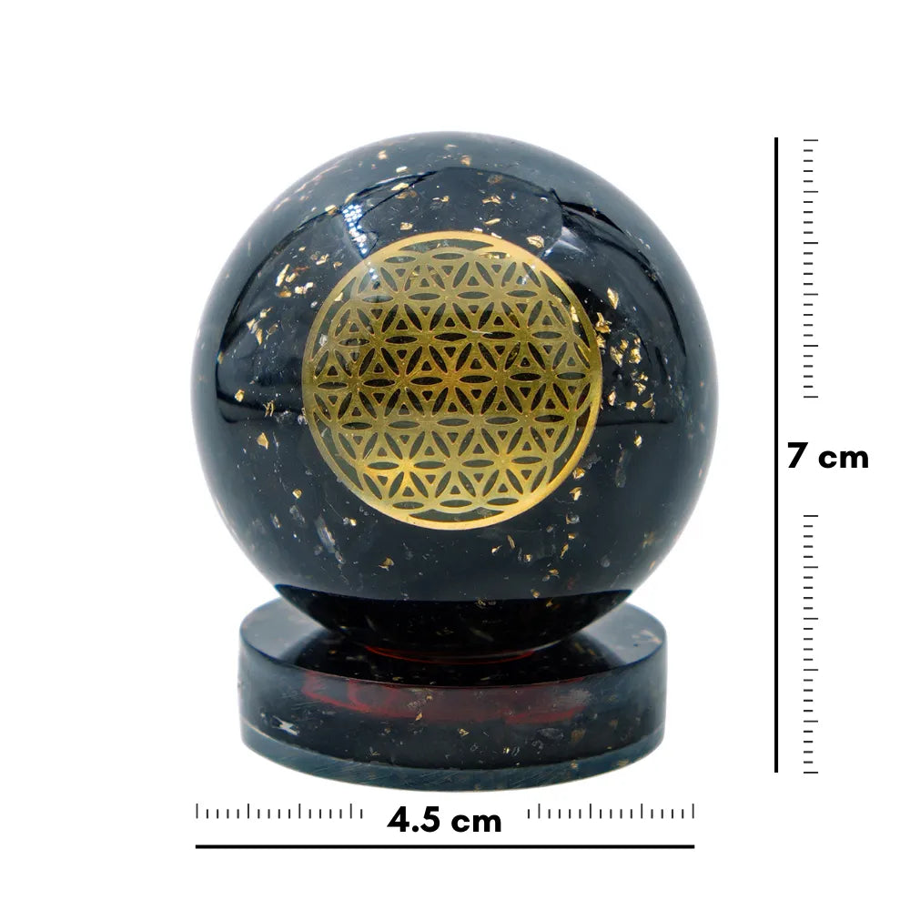 Black crystal ball with gold geometric design and measurement scale on a white background