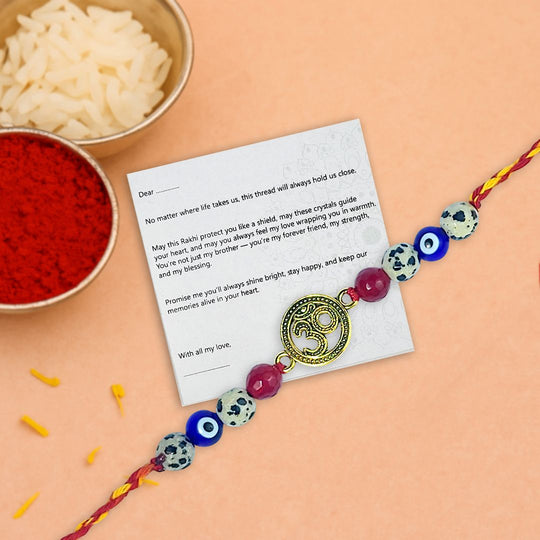 Decorative rakhi with beads and a card on a peach background