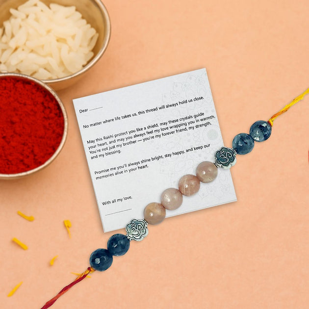 Rakhi with a message card on a peach background