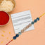 Rakhi with a message card on a peach background
