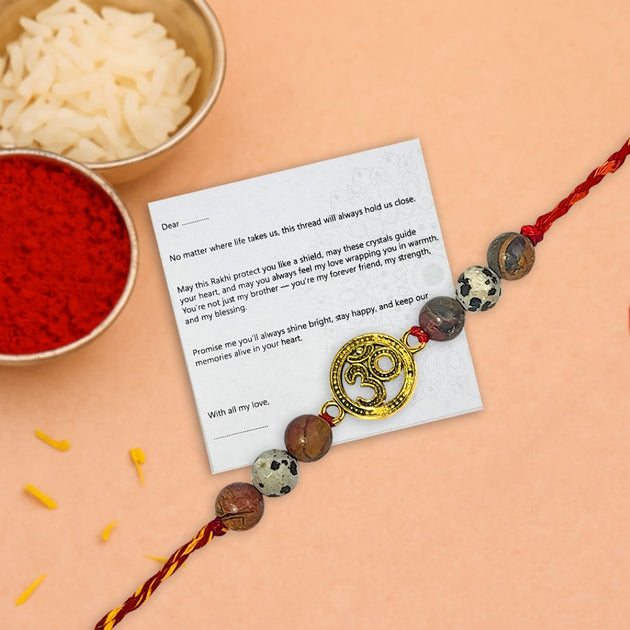 Rakhi with a message card on a peach background