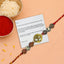 Rakhi with a message card on a peach background