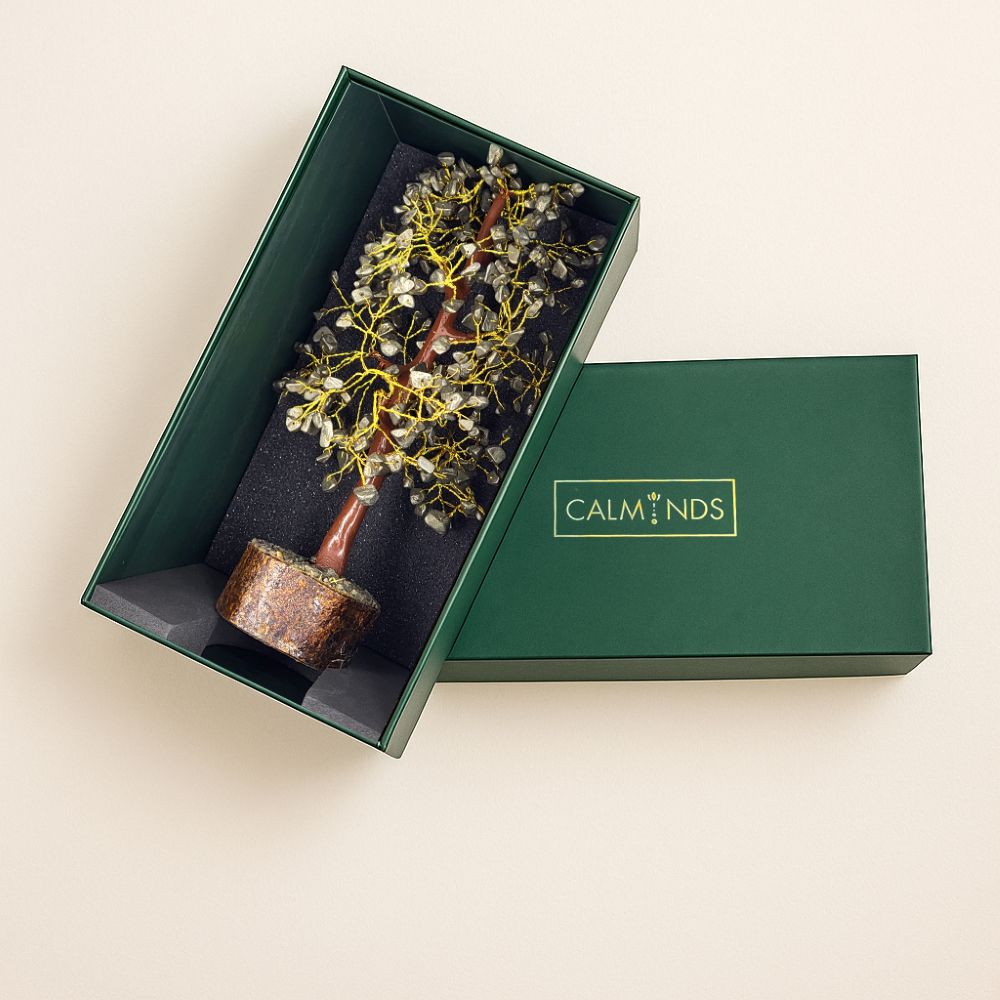 Calminds pyrite tree displayed in a green branded gift box, featuring a handcrafted gemstone tree with a stone base