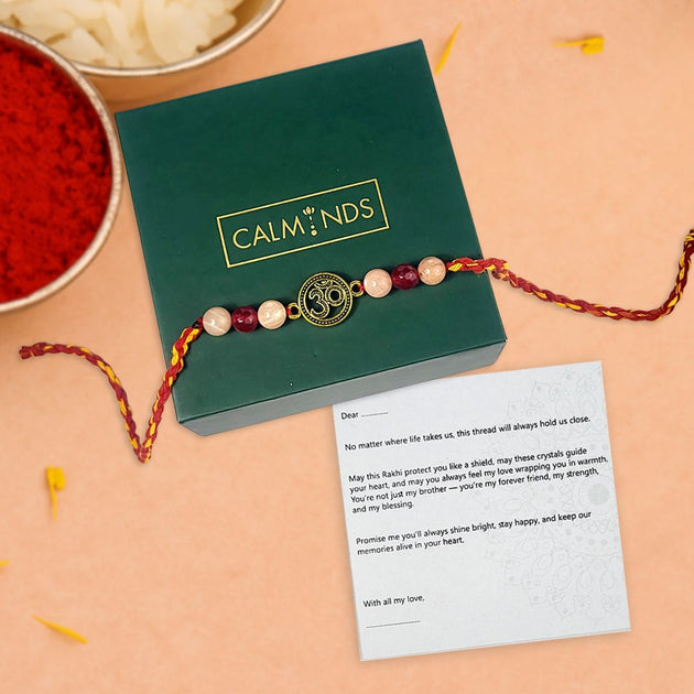 Rakhi with a message card on a beige surface, featuring the brand 'Calminds'.