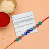 Colorful beaded Rakhi with a letter on a peach background