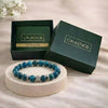 Blue beaded bracelet on a white stand with 'CALMINDS' branded box in the background.