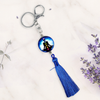 Keychain with blue tassel and decorative bead on a light background