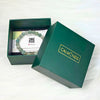 Green jewelry box with a bracelet and card inside, featuring the brand 'CALM NDS'.