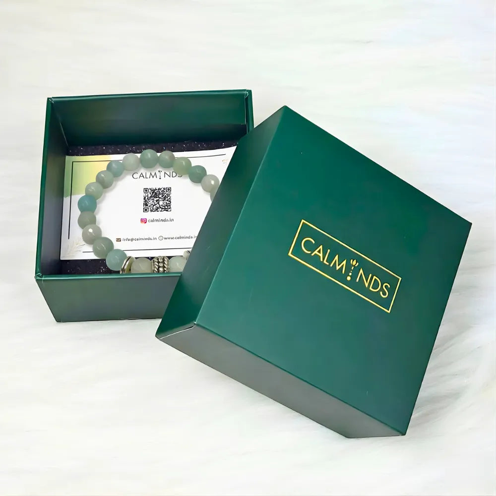 Green jewelry box with a bracelet and card inside, featuring the brand 'CALM NDS'.