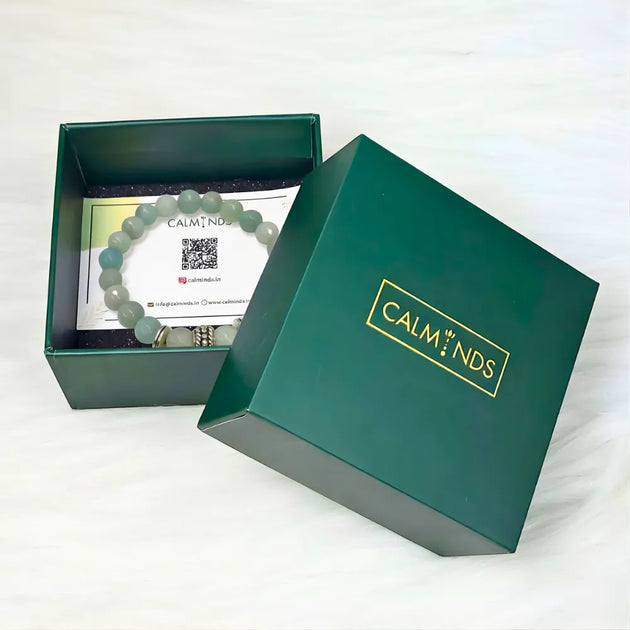 Green jewelry box with a bracelet and card inside, featuring the brand 'CALM NDS'.